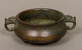 A Chinese patinated bronze censer Of squat circular form with twin dragon mask handles,