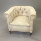 An Edwardian button back upholstered tub armchair