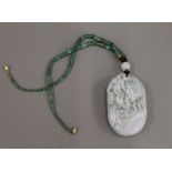 A carved Chinese jade pendant pebble and bead necklace