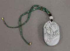 A carved Chinese jade pendant pebble and bead necklace