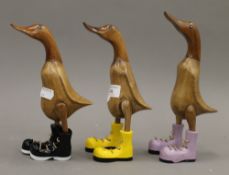 Three small wooden ducks in boots