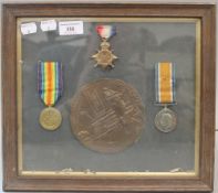 A framed group of WWI medals and death plaque,