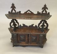 A Victorian carved oak hanging cupboard. 61 cm wide.