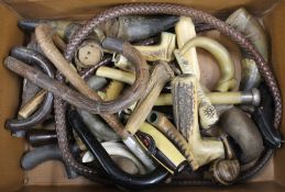 A suitcase containing a collection of walking stick and parasol handles, etc.