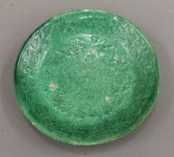 A Chinese pottery Laio plate, with moulded floral decoration on a green ground. 14 cm diameter.