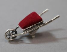 A silver wheelbarrow form pin cushion