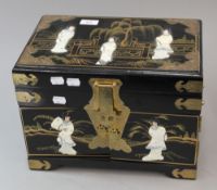 A japanned jewellery casket, worked with females figures in a fenced garden. 35.