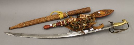 A brass handled sabre and two other bladed weapons