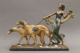 An Art Deco plaster group of a lady walking a pair of dogs