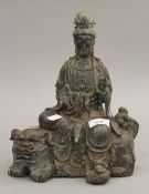 A bronze model of Guanyin seated on a dog-of-fo