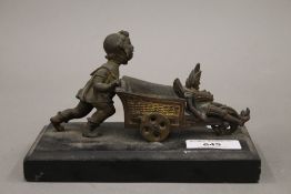 A small bronze model of a young girl pushing a pram
