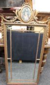 A gilt framed mirror with fabric inset panel