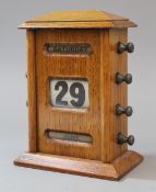 An early 20th century oak desk calendar