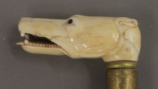 A walking stick with carved bone dog's head handle