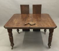 A Victorian oak two leaf extending dining table