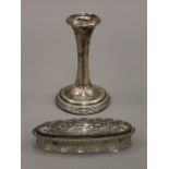 A silver candlestick and an embossed silver topped cut glass jar