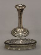 A silver candlestick and an embossed silver topped cut glass jar