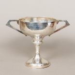 A George V silver twin handled trophy cup, of pedestal form, with twin angular handles,