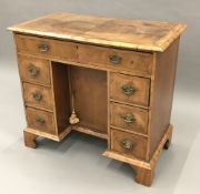 An 18th century style walnut kneehole desk,