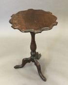 A 19th century mahogany wine table with shaped top. 47 cm diameter.
