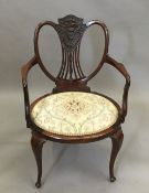 An Edwardian carved mahogany open armchair