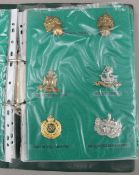 A folder housing a collection of military cap badges