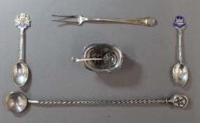 A sterling pickle fork, two silver and enamel souvenir teaspoons,