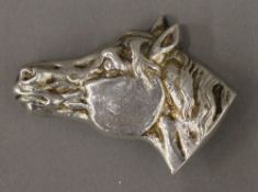 A silver horse head brooch