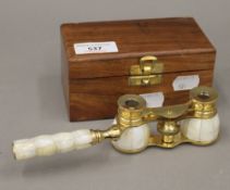 A pair of mother-of-pearl opera glasses in a wooden box