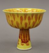 A Chinese porcelain stem cup, with all over yellow and red decoration,