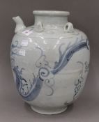 A large Chinese pottery blue and white spouted vessel decorated with a dragon chasing a flaming