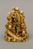 A carved ivory netsuke worked with various figures,