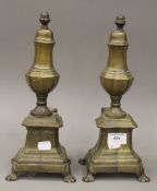 A pair of brass fire dogs