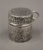An embossed silver round pill box