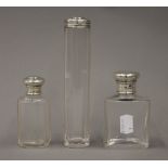 Two antique silver topped cut glass scent bottles and a silver topped glass jar
