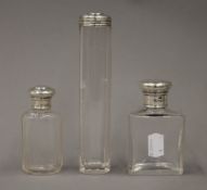 Two antique silver topped cut glass scent bottles and a silver topped glass jar