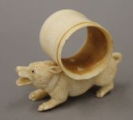 A bone napkin ring formed as a dog