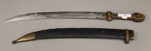 A Jambiya type sword and scabbard, the steel blade gently curved and stamped,