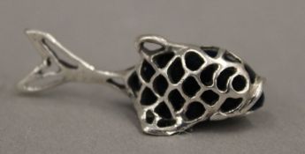 A silver pin cushion formed as a fish