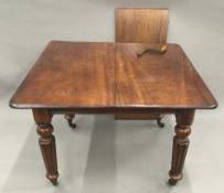 A Victorian mahogany single leaf wind out extending dining table