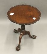 A mahogany wine table with pie crust top, with claw and ball foot,