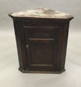 An 18th century oak hanging corner cupboard with panelled door