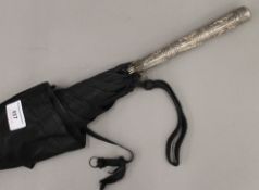 A 19th century parasol mounted with an Indian unmarked embossed silver handle