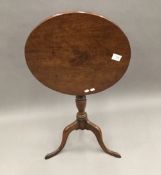 A George III mahogany country tripod table with tilt top,
