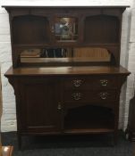 An Arts and Crafts oak stained lead glazed sideboard