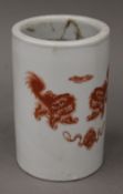 A Chinese porcelain brush pot decorated with iron red dogs-of-fo