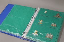 A folder housing a collection of military cap badges