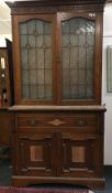 An Art Nouveau walnut secretaire bookcase cabinet, the upper section lead glazed,