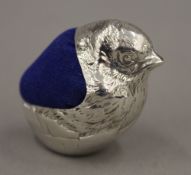 A silver pin cushion formed as a bird