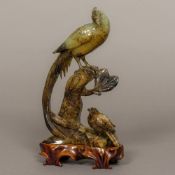 A Chinese carved jade group Worked as an Asiatic pheasant perched atop a tree stump another bird